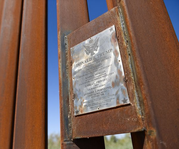 A welded plaque with the name of former President Donald J. Trump commemorates construction of 100 miles of wall