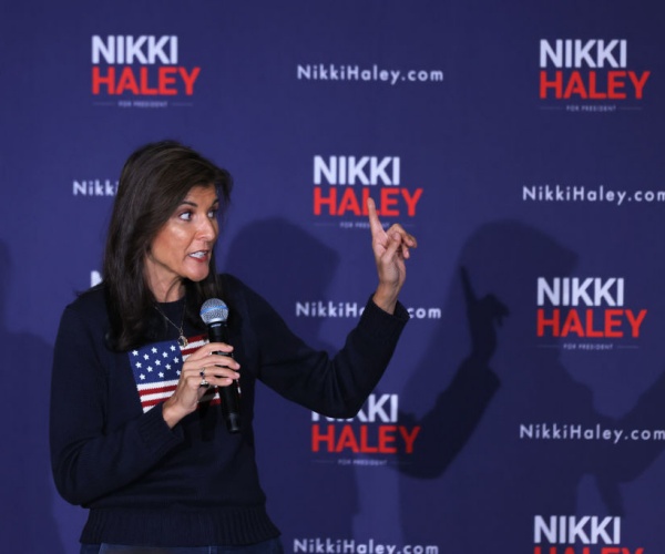 nikki haley gestures in american flag sweater with her name in background