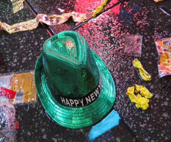 a happy New Year's hat, blower and other garbage on ground after a New Year's party