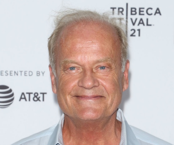 close up of kelsey grammar with blue eyes and light gray open shirt