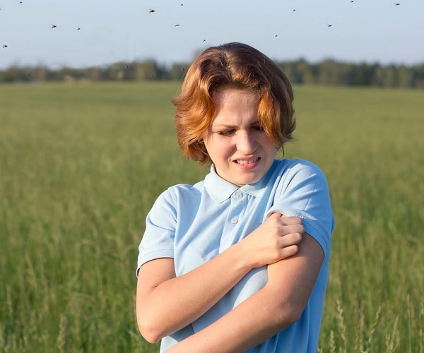 a boy scratching his arm