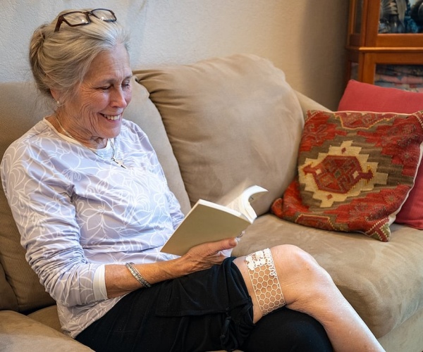 woman sitting on couch wearing the mesh sleeve