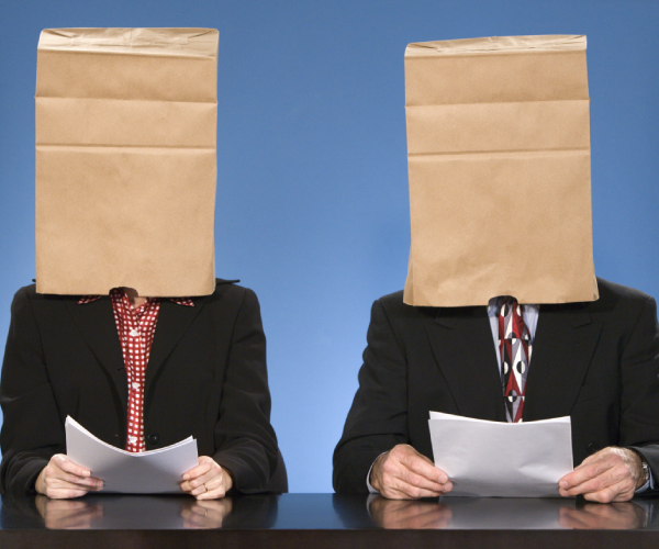 two news anchors with paper bags over their heads