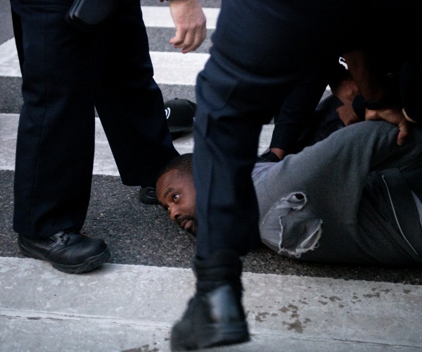 man handcuffed on ground as police stand over him