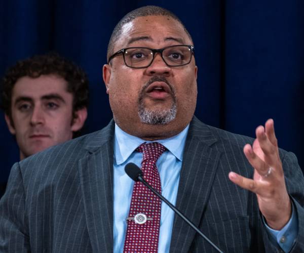 alvin bragg speaking at a microphone