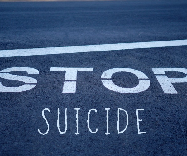 STOP SUICIDE road sign on pavement