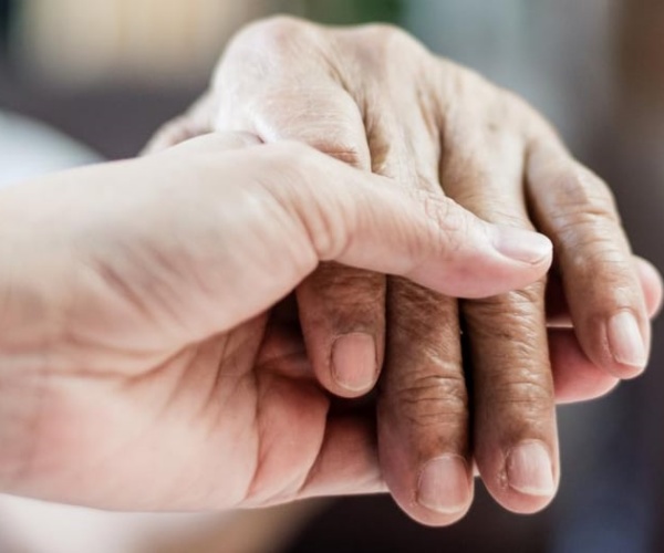 close up of a person holding another person's hand to calm them