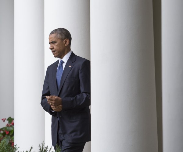 former president barack obama walks at the white house in 2015