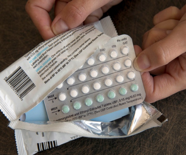 woman opening up birth control packet