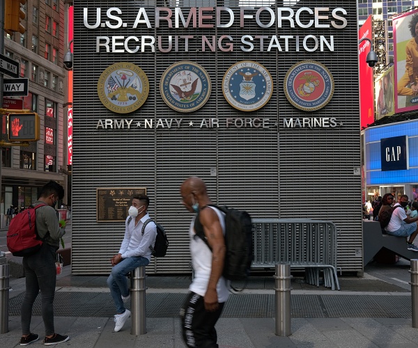 people walk past military recruitment center