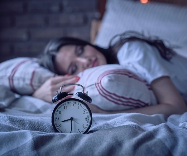 woman sleeping in bed in dark room