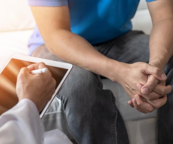 doctor reviewing medical records with male patient