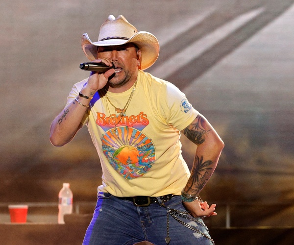 jason aldean sings into mic onstage