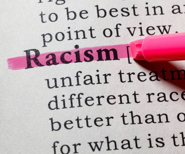 the word racism highlighted in a dictionary