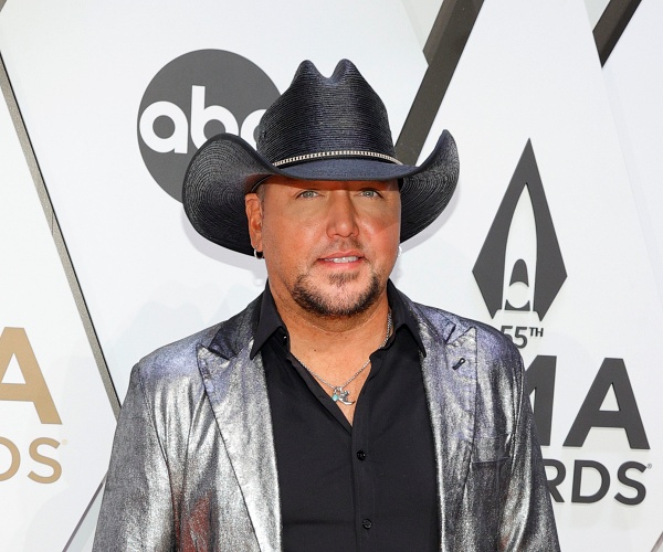 jason aldean stands on red carpet