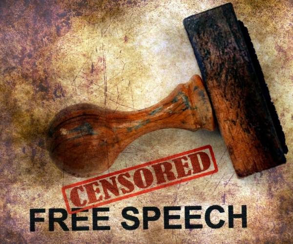 the words free speech with censored stamped over them and the stamp lying on top