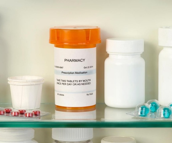 inside a medicine cabinet with a prescription vial and other medications