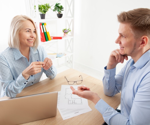 older boss talking to a younger employee in office