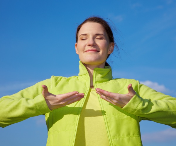 woman outside doing breathing exercise