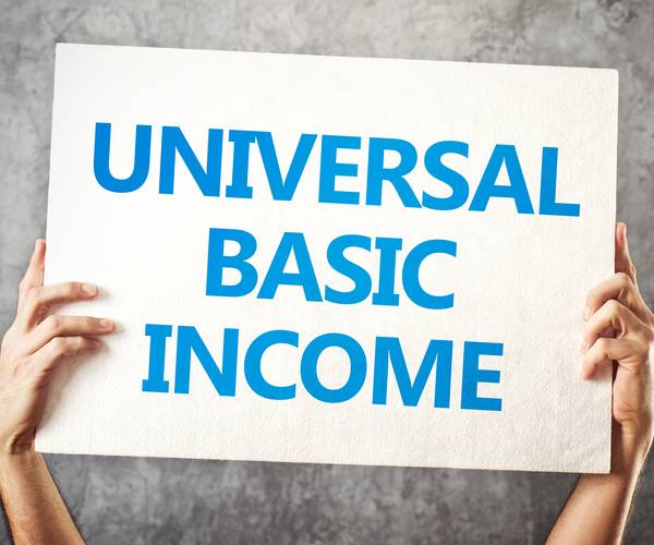 hands holding up a sign reading universal basic income