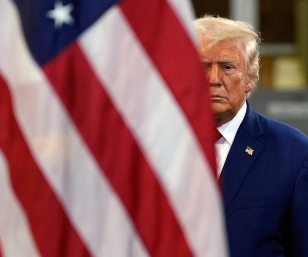 donald trump behind a us flag