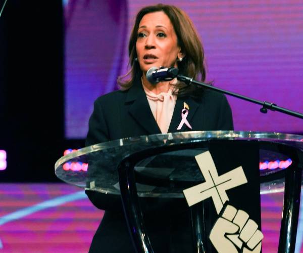 kamala harris at a church pulpit with a cross on it