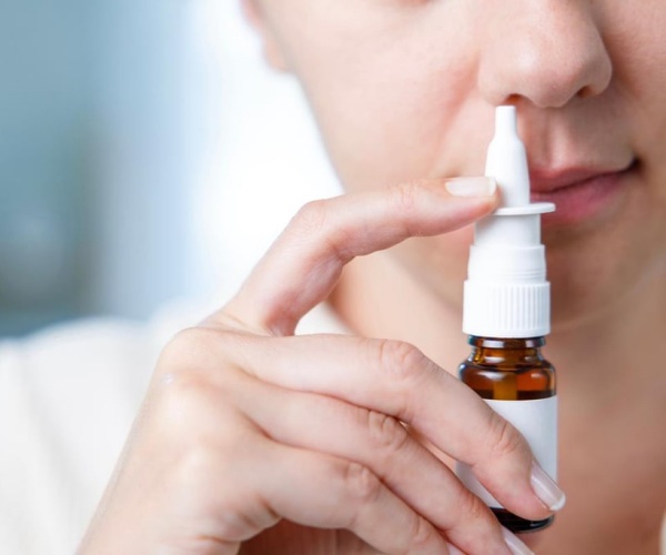 woman using a nose spray