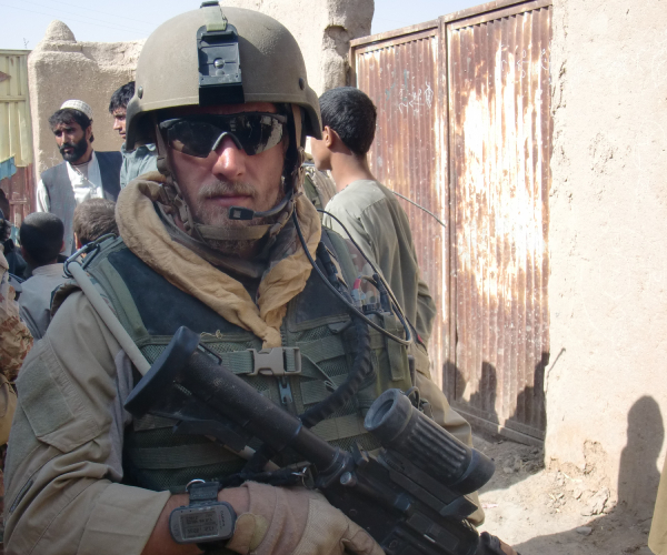 martin tamm anderson wears fatigues and holds a gun