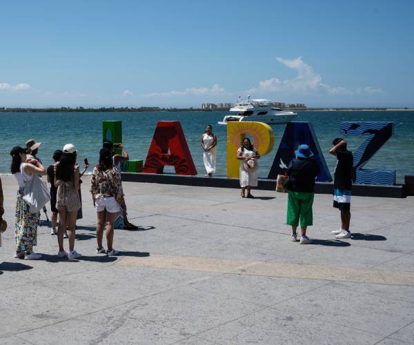 tourists take photos at a la paz sign 