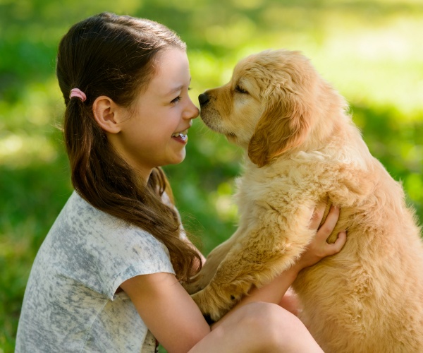 girl looking into eyes of puppy