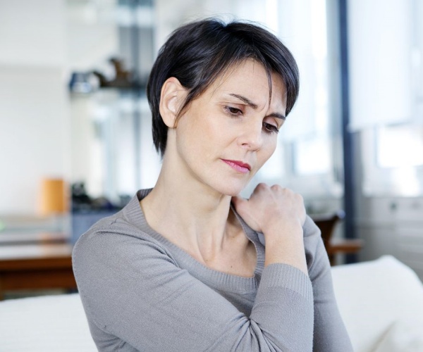 woman holding painful shoulder