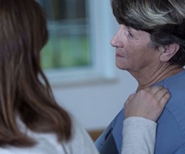 healthcare worker comforting woman with dementia