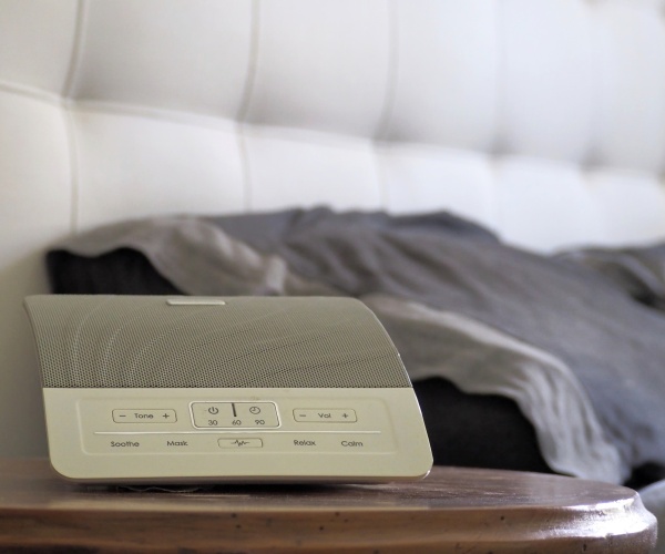 white noise machine on side of bed