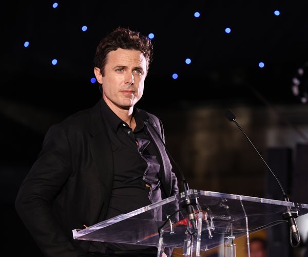 Casey Affleck looks on from behind a podium