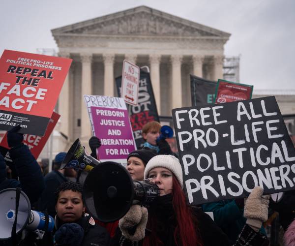 protesters hold signs