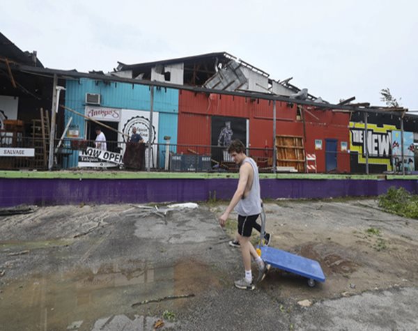 person walking past damaged building