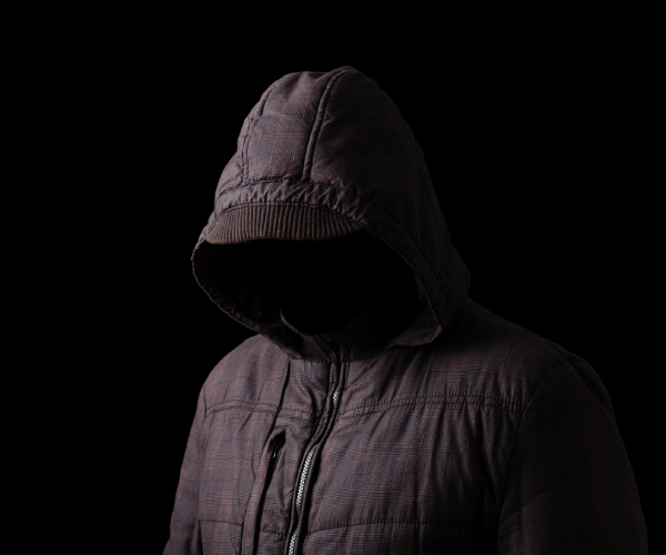 faceless man in hooded jacket in the dark