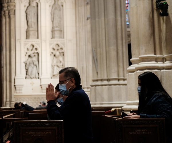 man kneels in church