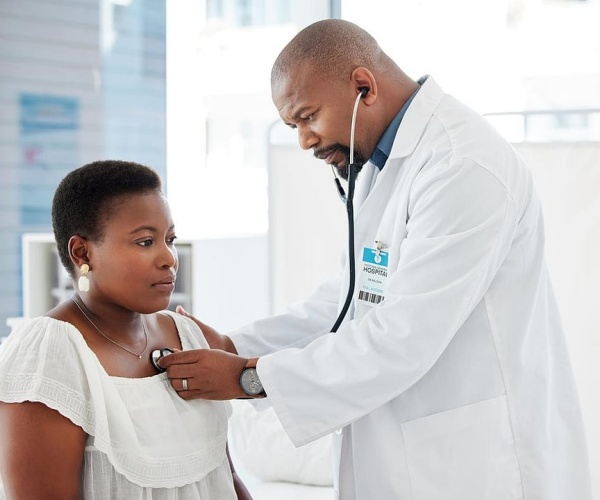 doctor listening to patient's heart with stethoscope