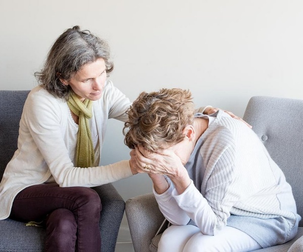 Woman comforting another woman in distress