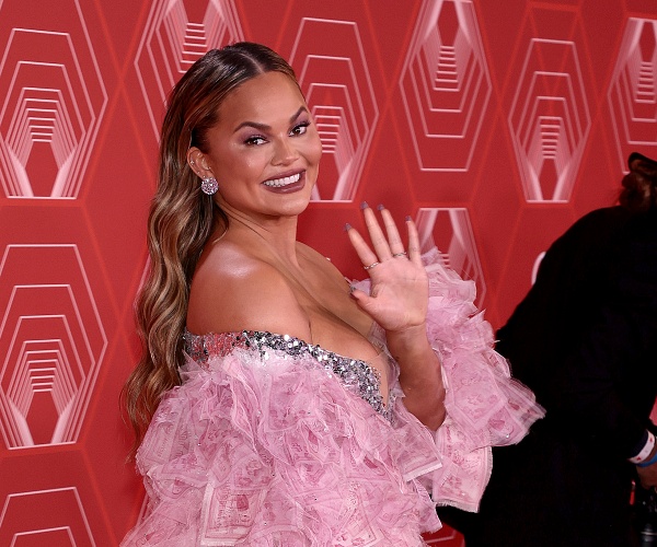 chrissy teigen waves on red carpet