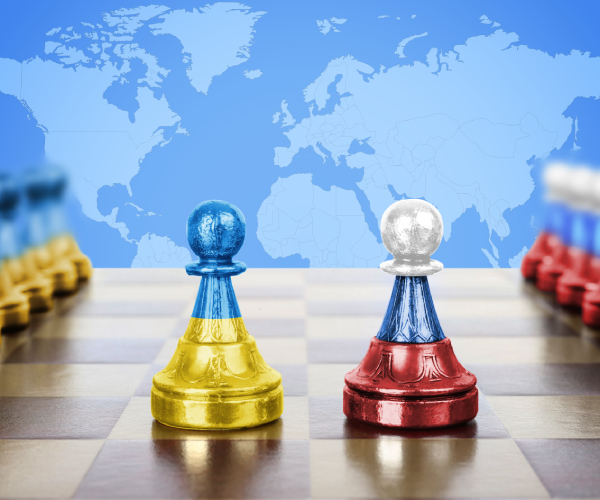 chess pawns painted as the ukrainian and russian flags with a map of the world in the background