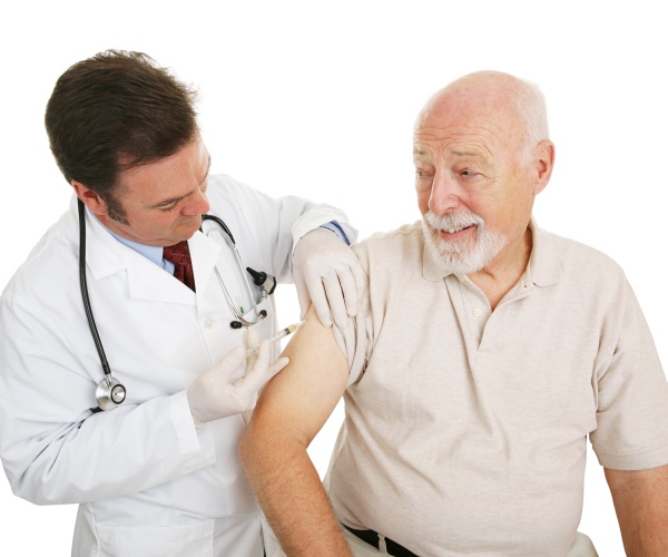 older man receiving a vaccine from a healthcare worker