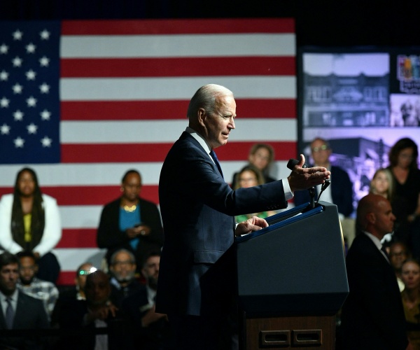 joe biden standing in front of a flag in tulsa