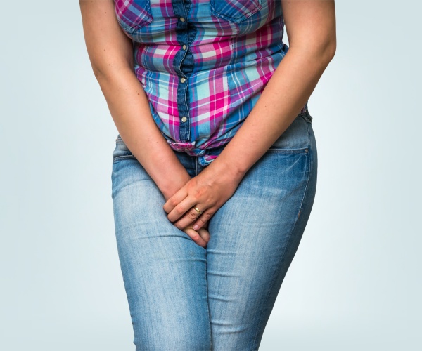 woman with legs crossed, holding in her urine