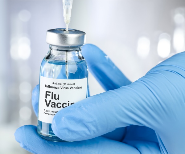 syringe in vial labeled 'flu vaccine'