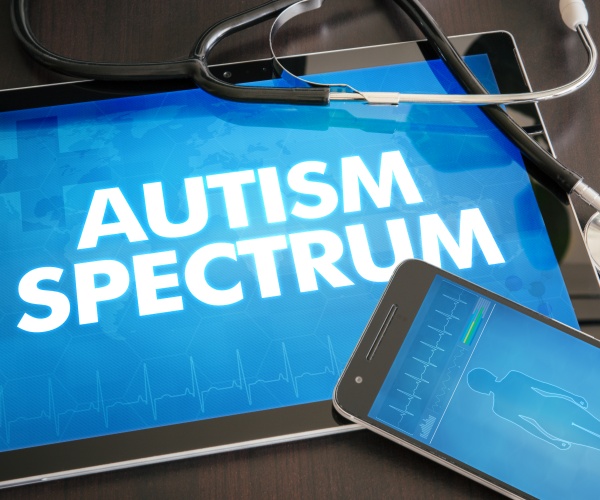 Autism Spectrum on tablet screen, iPhone screen, stethoscope