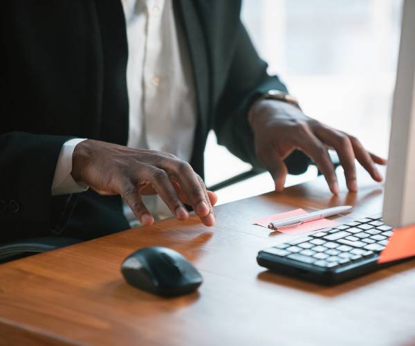 a man holding his hands near a computer keyboard