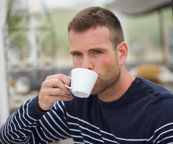 a man drinking a cup of coffee