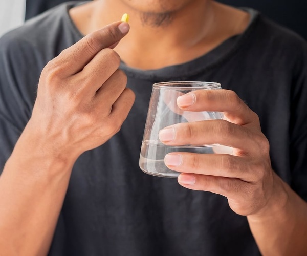 man taking a supplement